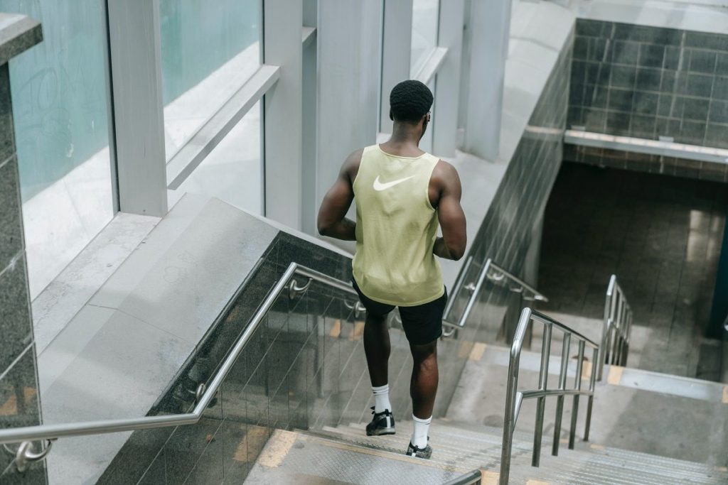 Homem com uma camiseta da Nike descendo escada