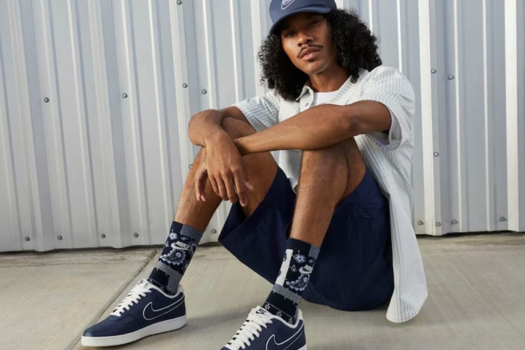 Homem sentado usando um Nike Court Vision azul