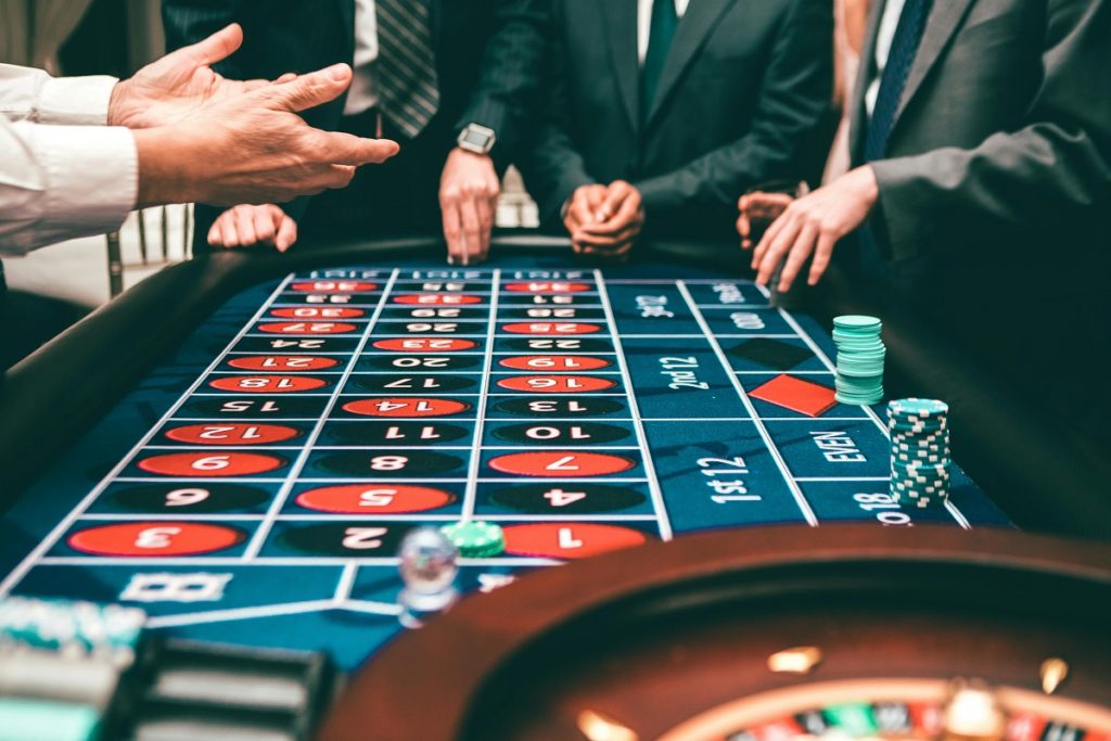 Homens reunidos em uma mesa de apostas